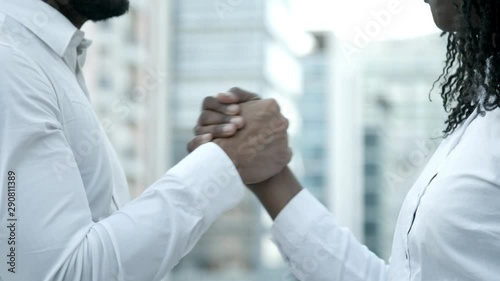 Slow motion shot of people shaking hands on street. Bearded man and woman with dreadlocks meeting on street and talking. Handshake concept