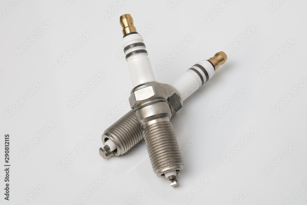 © Дмитрий Ногаев - Two car spark plugs lie on a white table