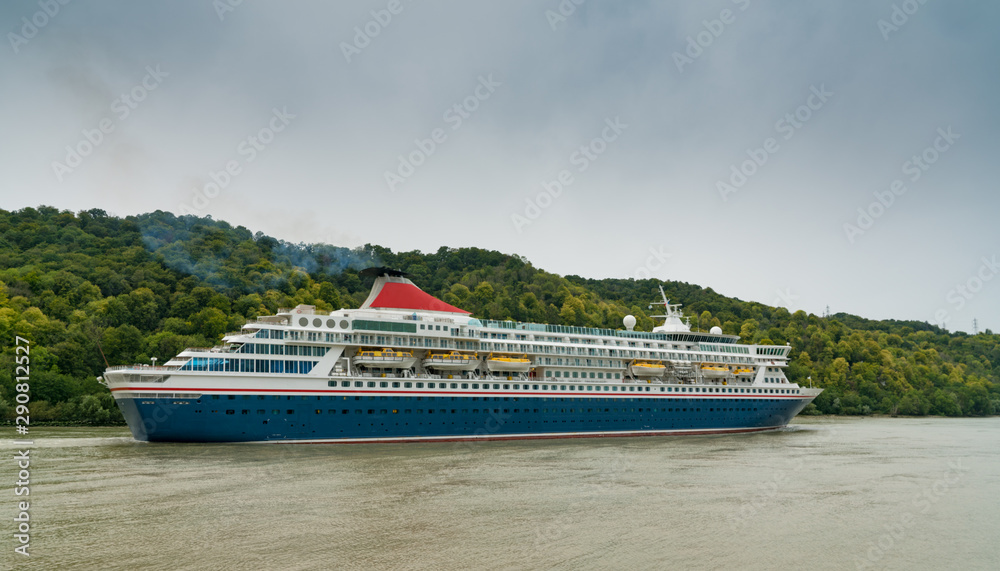 blue and white cruise ship traveling along the Seine River from Paris to the English Channel blue and white cruise ship traveling along the Seine River from Paris to the English Channel