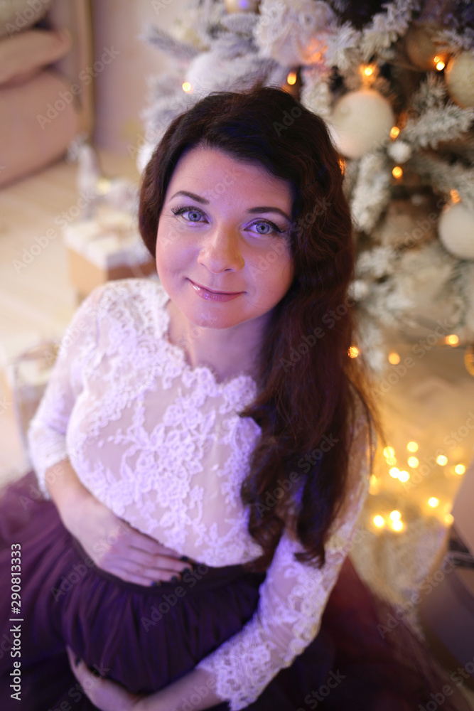 Pregnant girl in a beautiful interior studio celebrates Christmas and New Year Pregnant girl in a beautiful interior studio celebrates Christmas and New Year