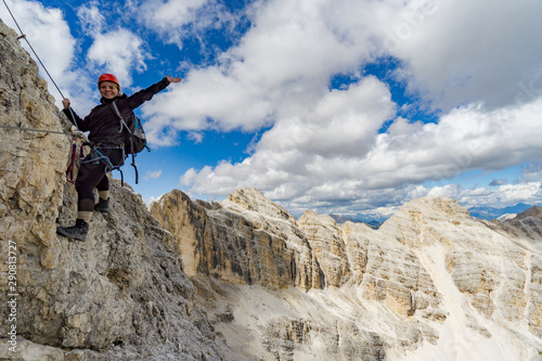female mountain climber on a steep Via Ferrata in the Italian Dolomites