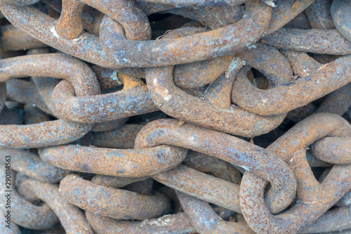 Stacked rusty iron chain as background.