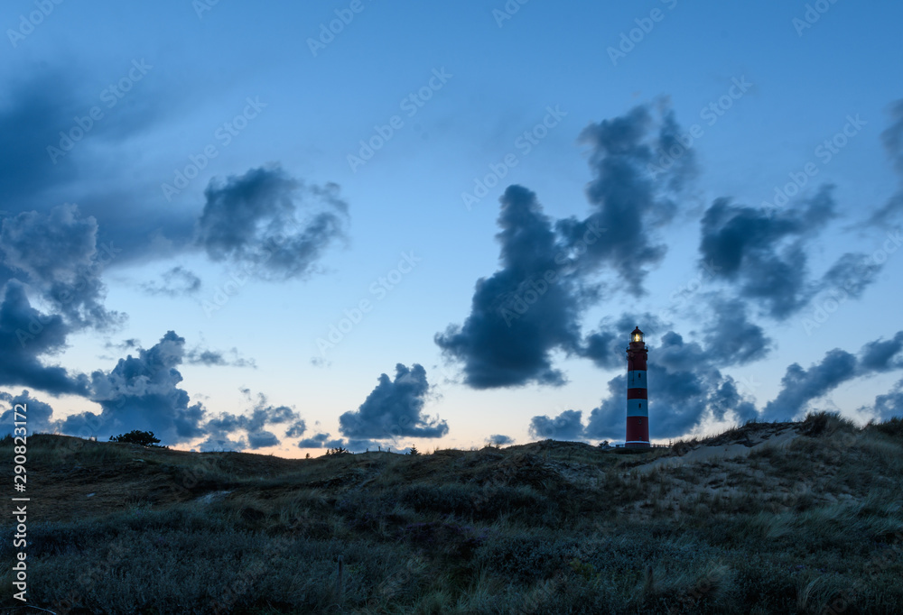 Leuchtturm auf Amrum am Abend vor blauem  Himmel mit Wolken