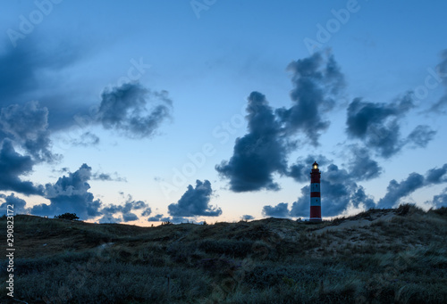 Leuchtturm auf Amrum am Abend vor blauem Himmel mit Wolken