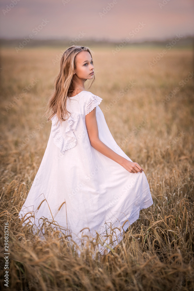 Obraz premium Portrait of a teenage girl in a wheat field