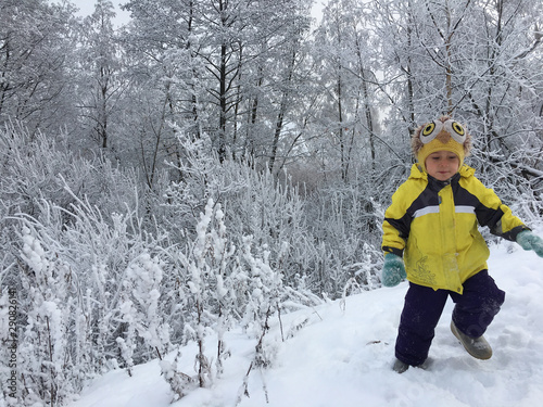 a child runs against the background of snow thickets