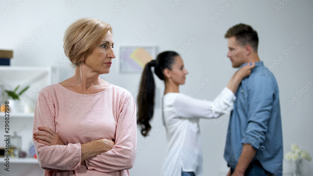 Mother-in-law with hands crossed disapproving young couple relations, loneliness Mother-in-law with hands crossed disapproving young couple relations, loneliness