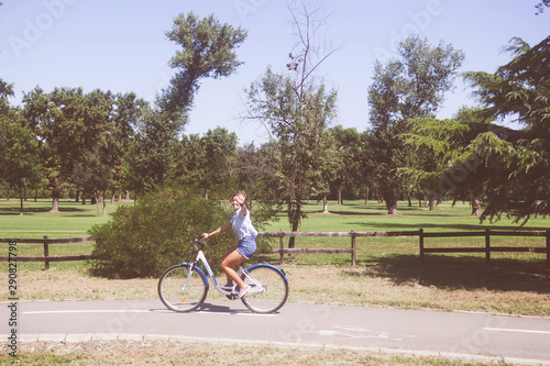  Young Woman Riding Bicycle In The Park