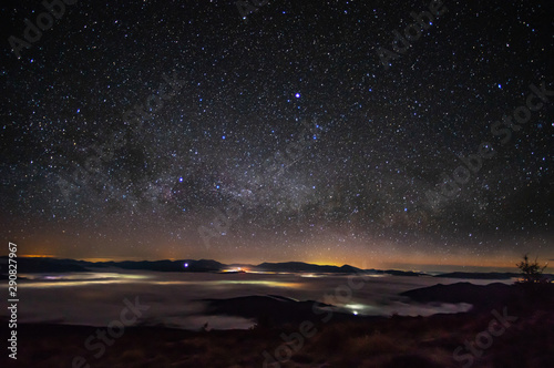 Panorama of the starry sky over the foggy mountains