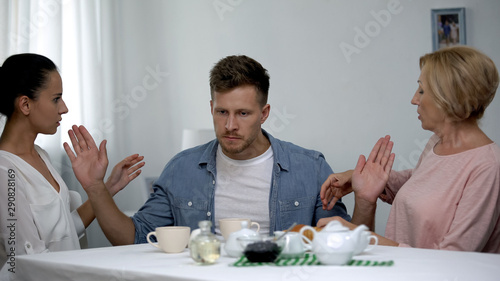 Male rejecting mother and wife, trying to stop confrontation of females, problem