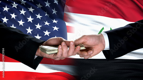 USA and Iraq officials exchanging money, flag background, trade partnership