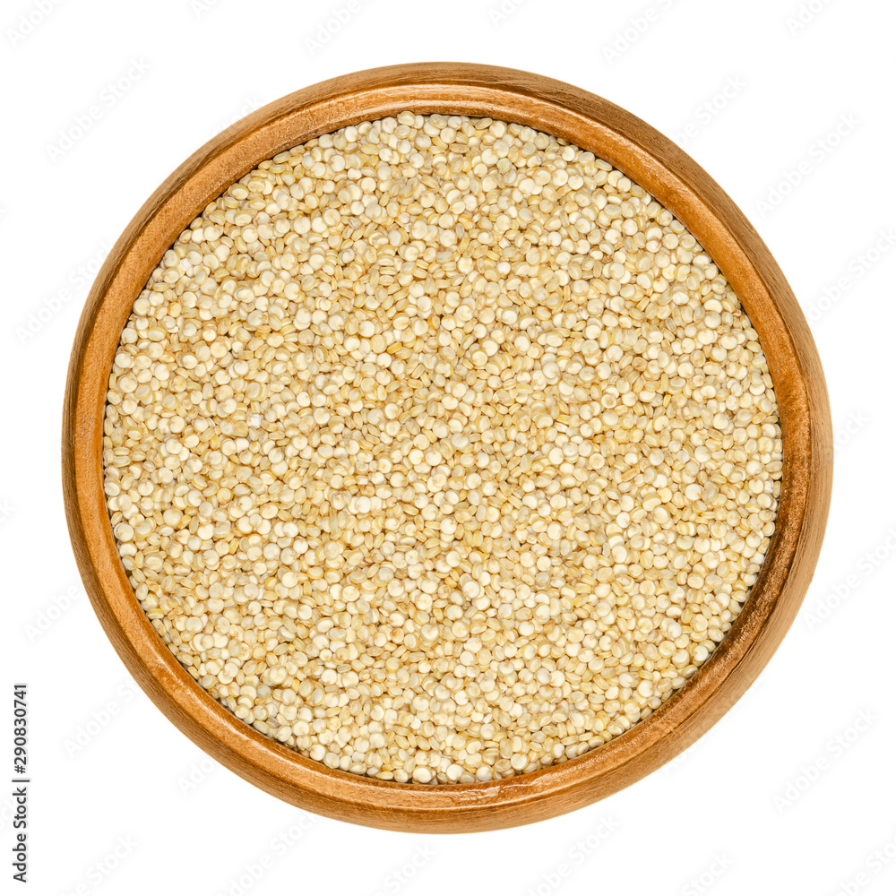White quinoa in wooden bowl. Raw dried seeds of Chenopodium quinoa, a gluten-free pseudocereal, originated in the Andean region. Closeup, from above, on white background, isolated macro food photo. White quinoa in wooden bowl. Raw dried seeds of Chenopodium quinoa, a gluten-free pseudocereal, originated in the Andean region. Closeup, from above, on white background, isolated macro food photo.