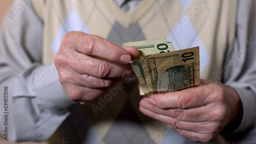 Tableau sur toile Old male counting dollar banknotes, poverty problem, social insecurity, close-up