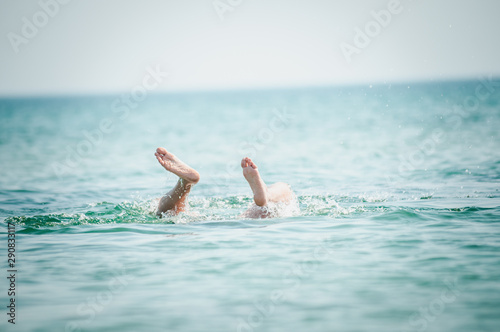 Man's legs sticking out of the water
