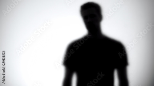 Silhouette of male looking at camera through white glass, statistic template photo