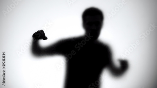 Canvas Print Silhouette of man behind glass attacking enemy, anonymous fight club, athlete