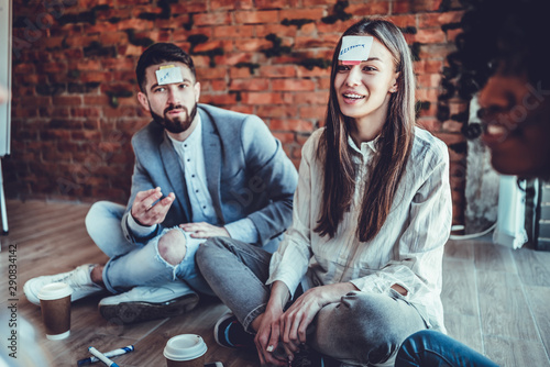 happy friends playing guessing game at home on the floor