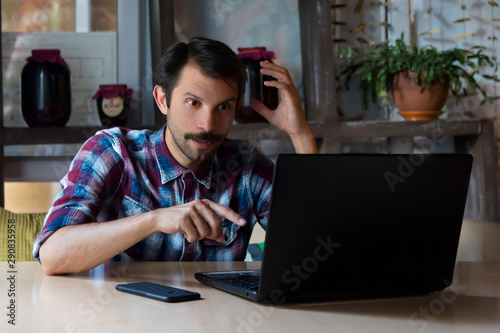 man is surprised to see the image on a laptop monitor obtained from the Internet photo