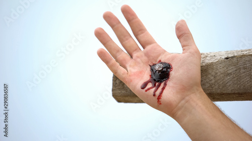 Jesus hand nailed to cross, clotted blood on wound, reenactment of crucifixion