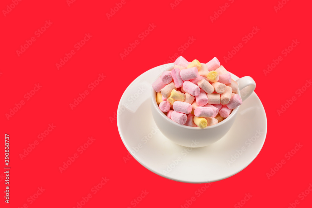 Cup with marshmallow on a red background. Copy space.