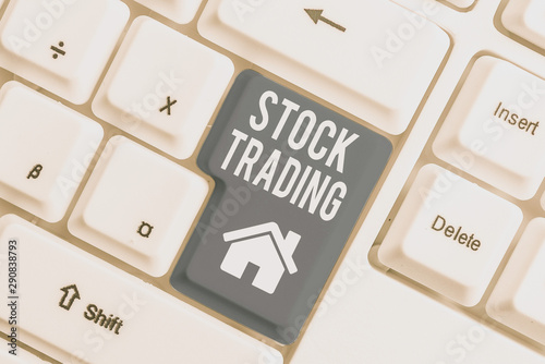 Conceptual hand writing showing Stock Trading. Concept meaning Buy and Sell of Securities Electronically on the Exchange Floor White pc keyboard with note paper above the white background photo