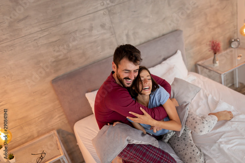 Couple hugging in bed