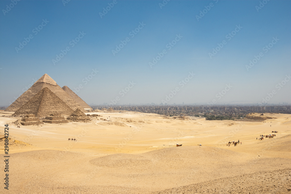 The Giza pyramid complex, also called the Giza Necropolis and Cairo Behind The Giza pyramid complex, also called the Giza Necropolis and Cairo Behind