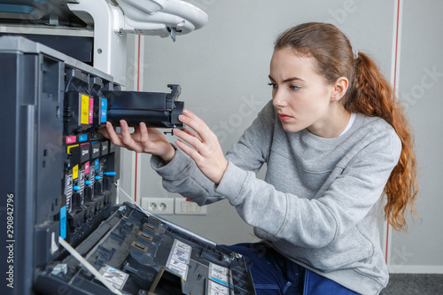 young female technician repairing digital printer