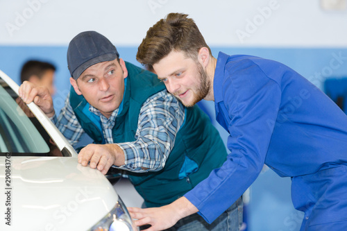 apprentice mechanic talking to teacher