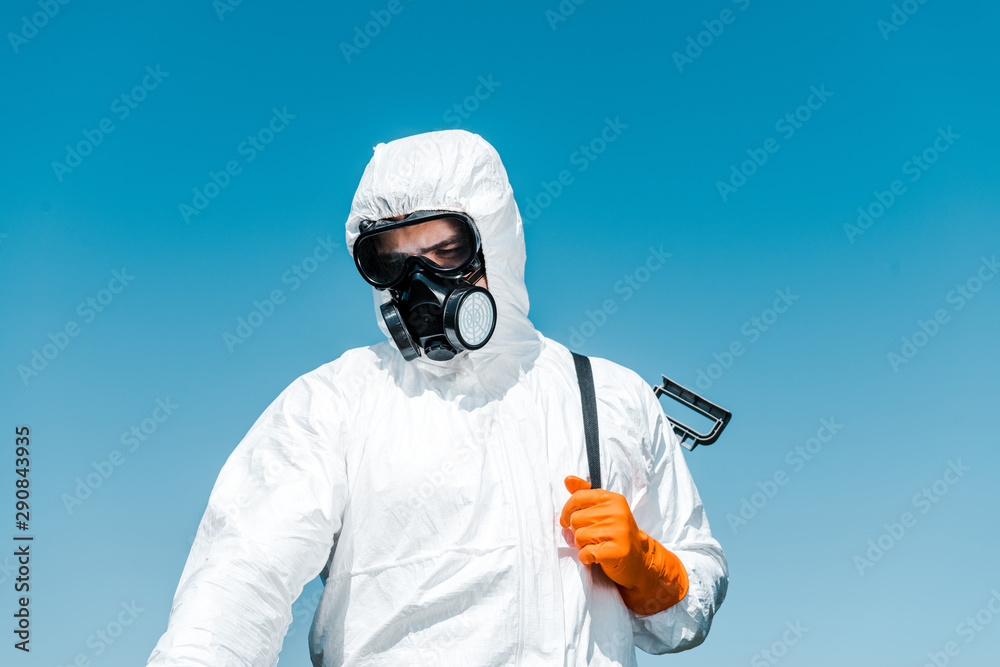 exterminator in white uniform and latex glove holding spray - obrazy, fototapety, plakaty 