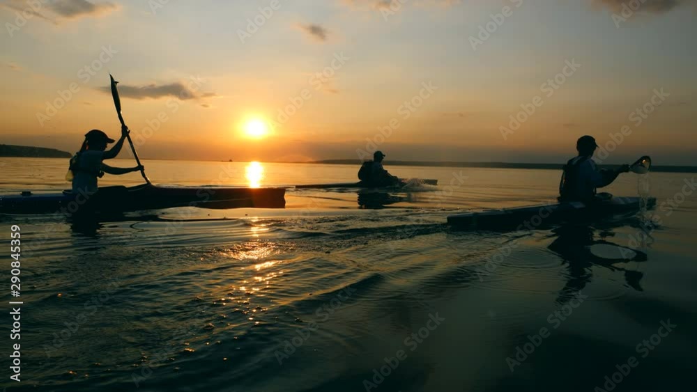 Sunset river and boaters rowing along it