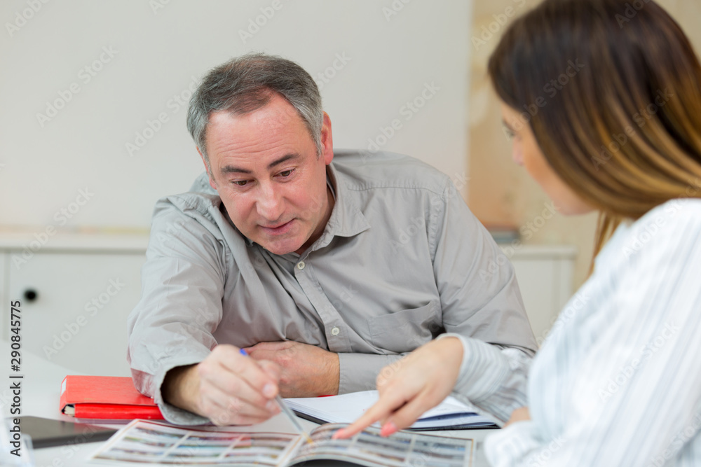 Obraz premium happy middle-age couple with brochure in office