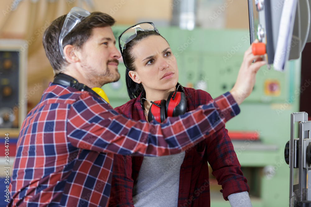 man and woman with machine cnc man and woman with machine cnc