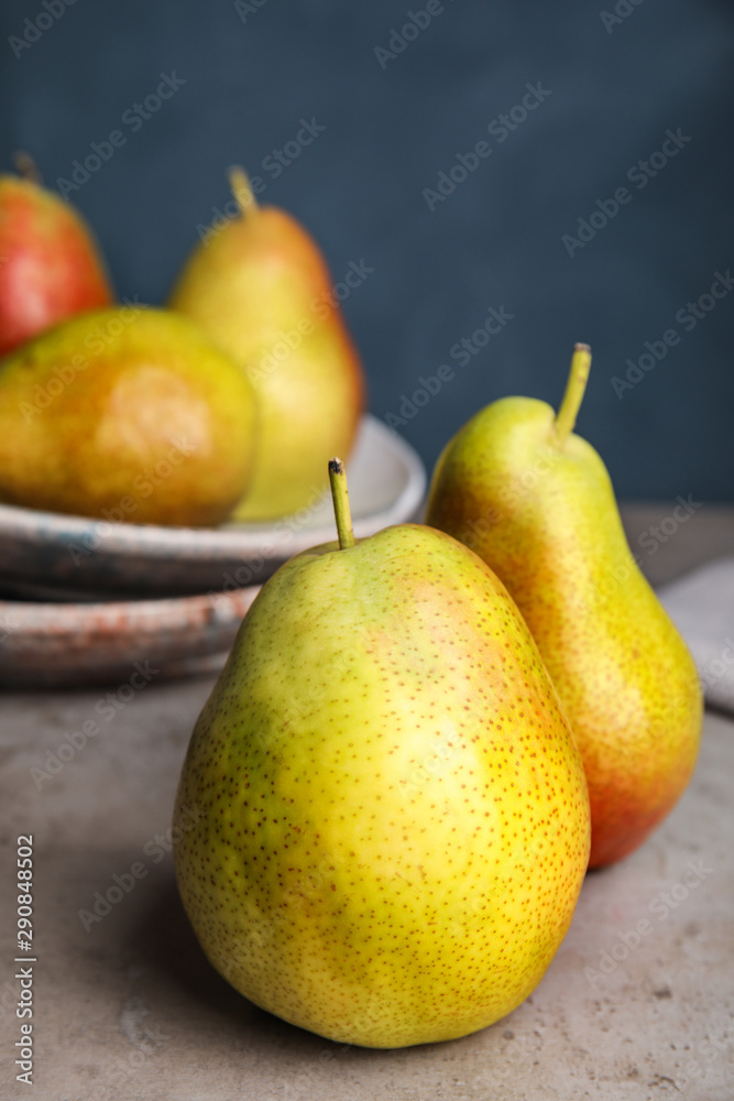 Ripe juicy pears on grey stone table against blue background Ripe juicy pears on grey stone table against blue background