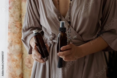 Woman's hands holding two glass brown bottles with spa cosmetics. Beauty blogging, salon therapy