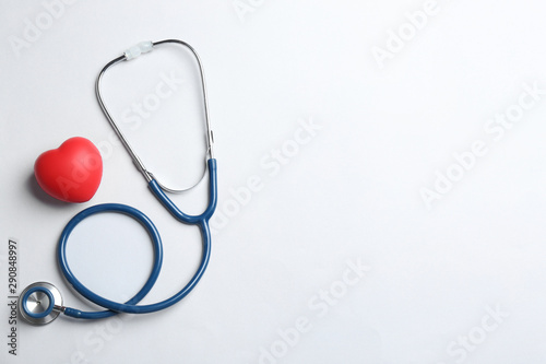 Stethoscope and red heart on white background, top view. Health insurance concept photo