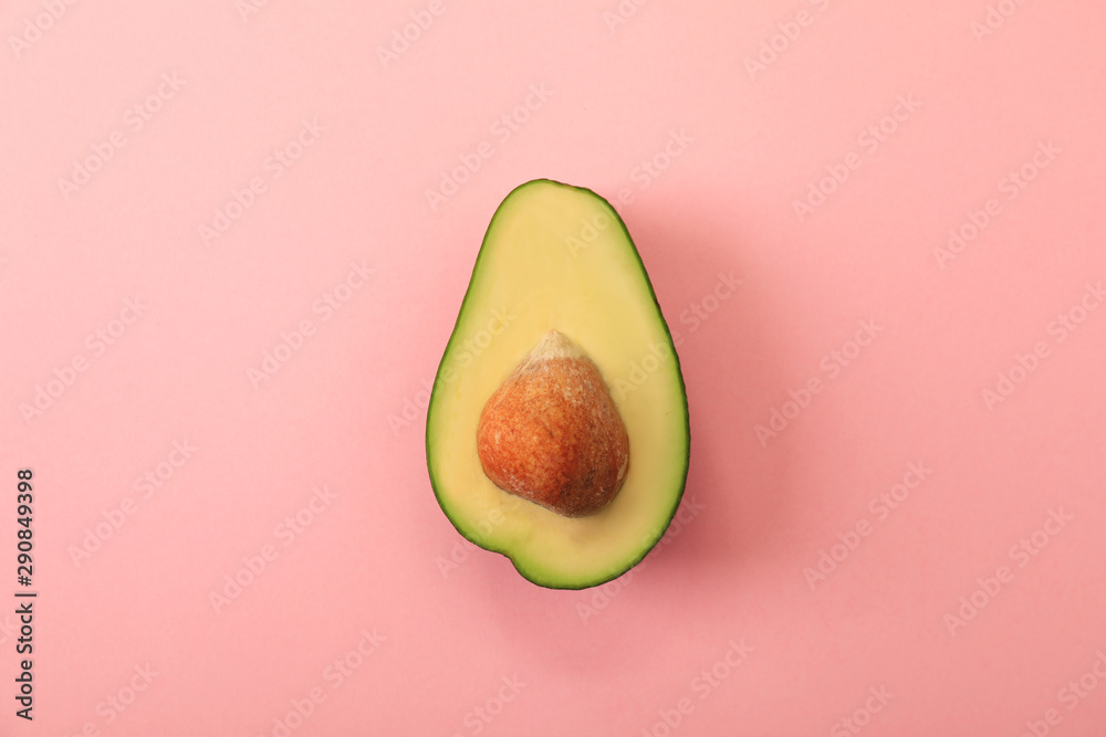 Half of delicious avocado on pink background, top view