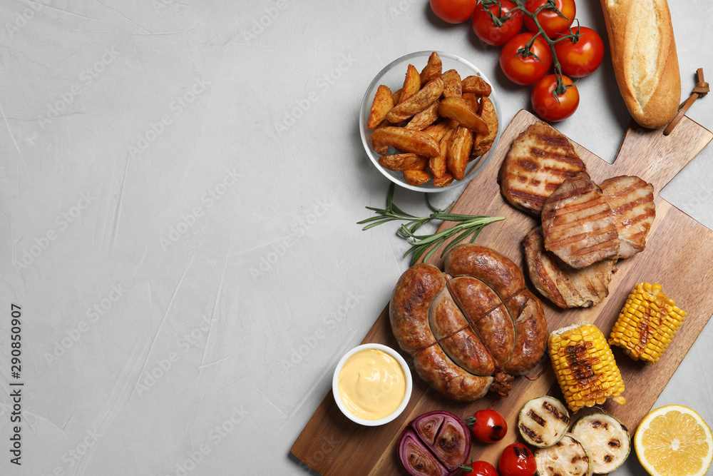 Flat lay composition with barbecued meat and vegetables on light table. Space for text Flat lay composition with barbecued meat and vegetables on light table. Space for text
