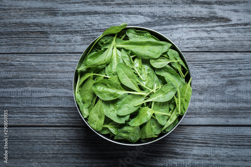 Fresh green healthy spinach on dark wooden table, top view