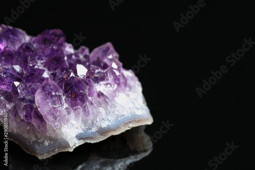 Beautiful purple amethyst gemstone on black background, closeup. Space for text
