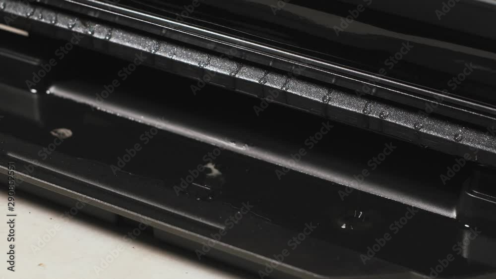 Fat flows from a bacon to a drip tray of a grill. Fat flows from a bacon to a drip tray of a grill.