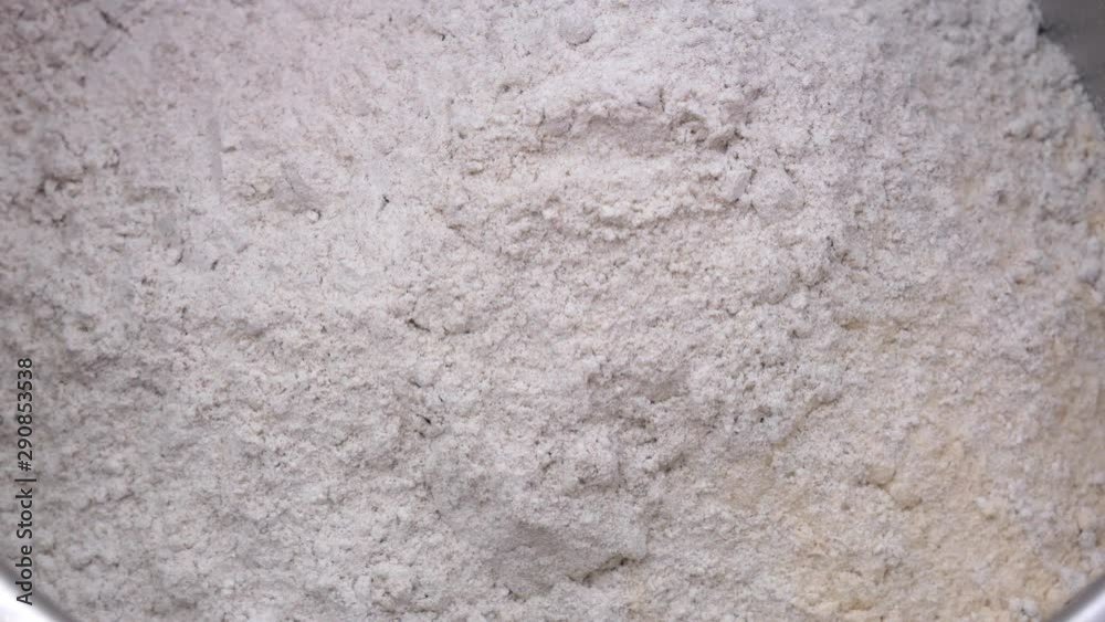 Preparation of homemade bread - pouring rye flour on wheat flour in a stainless steel bowl Preparation of homemade bread - pouring rye flour on wheat flour in a stainless steel bowl