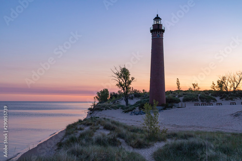 lighthouse on beach at sunrise