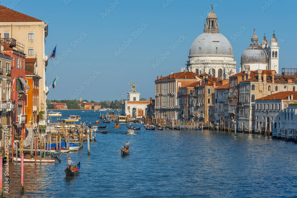 Beautiful Venetian view with Grand Canal, Basilica Santa Maria della Salute and traditional gondolas, in Venice, Italy