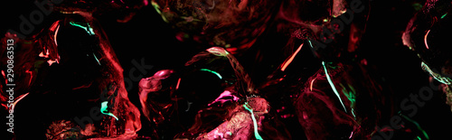 panoramic shot of clear ice cubes with red and green light isolated on black