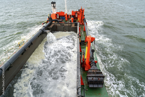 A Trailing Suction Hopper Dredger (TSHD) is mainly used for dredging loose and soft soils such as sand, gravel, silt or clay. One or two suction tubes, equipped with a drag head, are lowered on sea photo