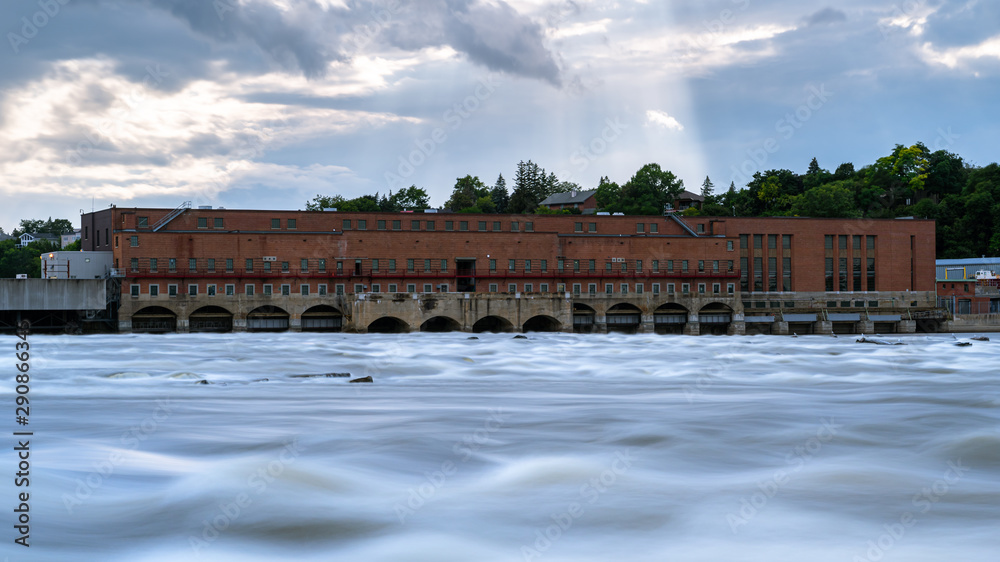 Old hydroelectric power station dam with sunbeams