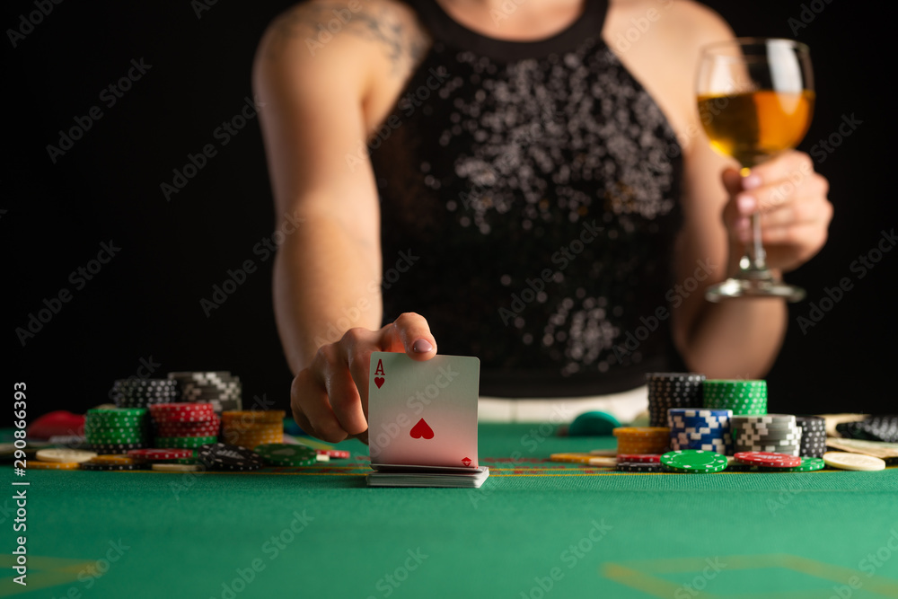 girl in evening dress plays poker draws a card in a casino. focus on the card and focus