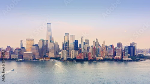 Drone footage with slow approach towards New York City skyline above Hudson river, at sunset