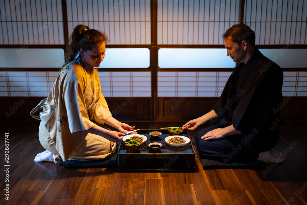 Young couple seiza sitting on floor pillows with traditional Japanese